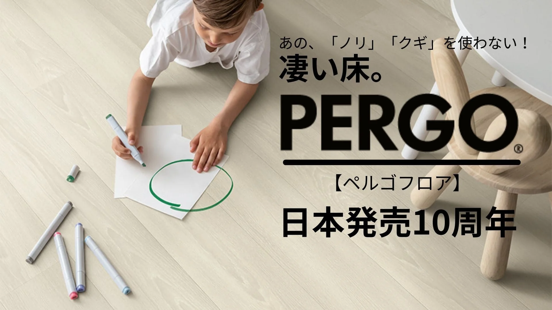 明るい木目調のフローリングの上で、子供がマーカーで絵を描いています。PERGO(ペルゴフロア)の「ノリやクギを使わない凄い床」というキャッチコピーと「日本発売10周年」の文字があり、床材の広告であることがわかります。