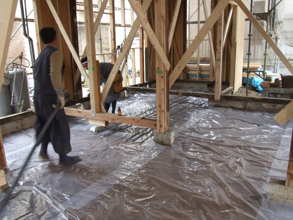 基礎工事中の木造建築物と作業員