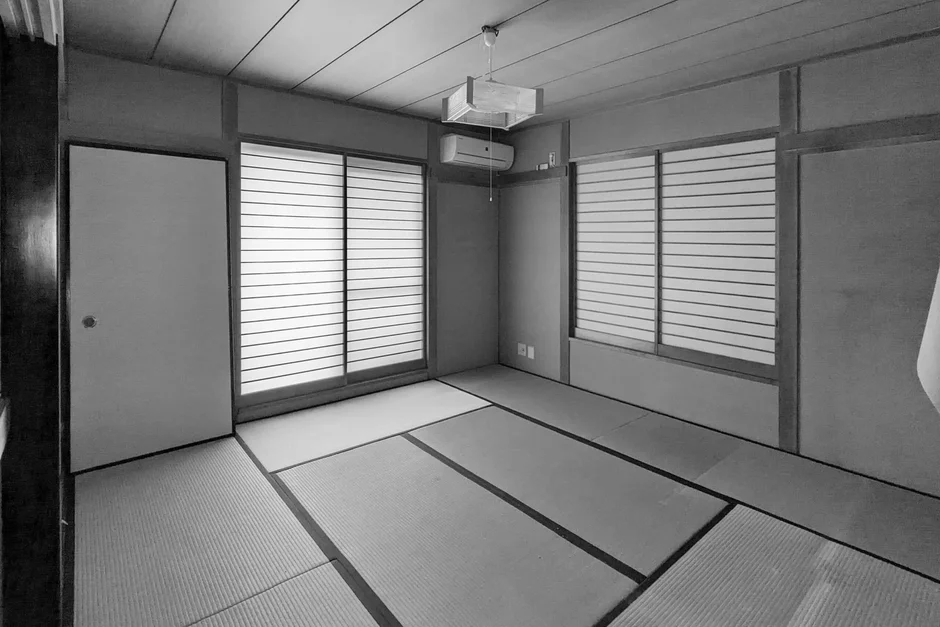 畳が敷き詰められた広々とした和室のモノクロ写真