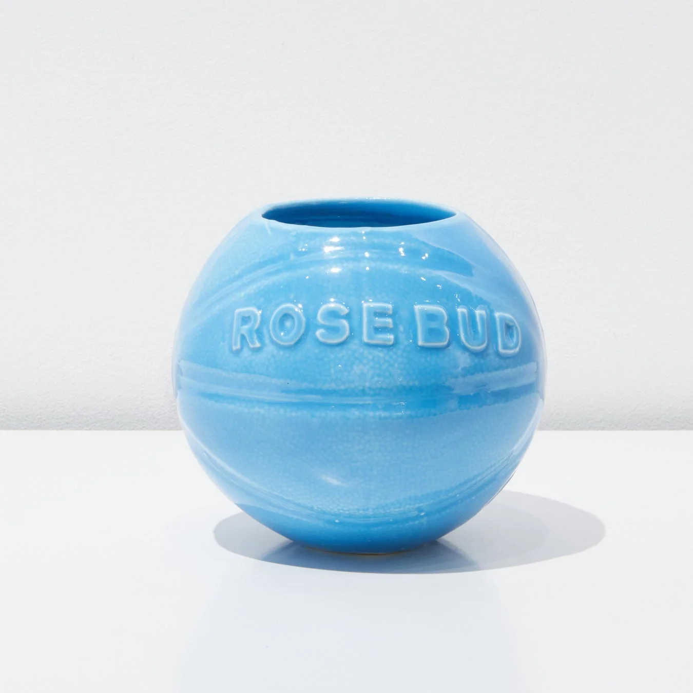 「ROSE BUD」の文字がエンボス加工された、水色の球状の陶器製花瓶です。