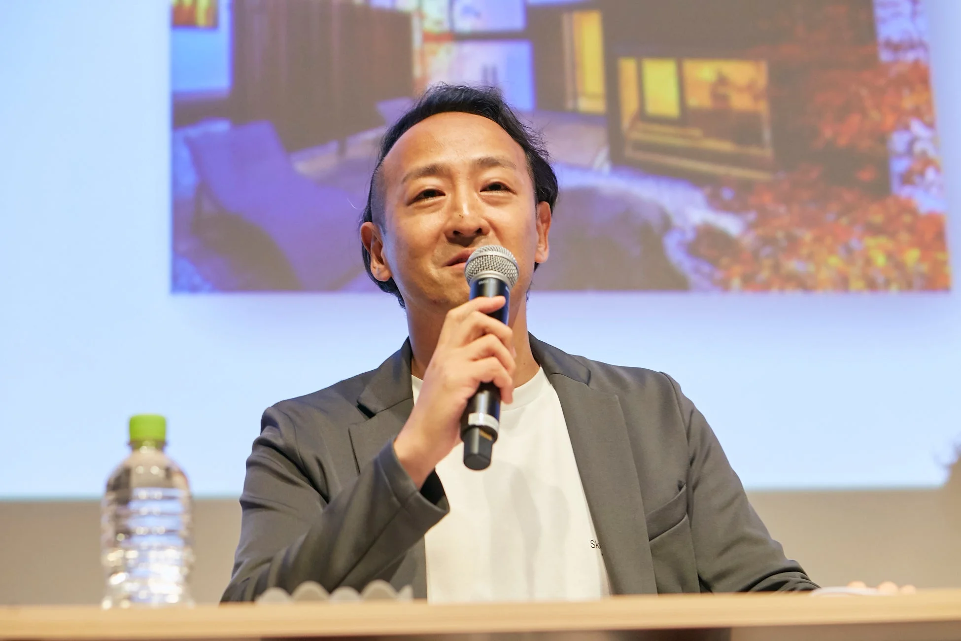 マイクを手に話す男性の講演風景