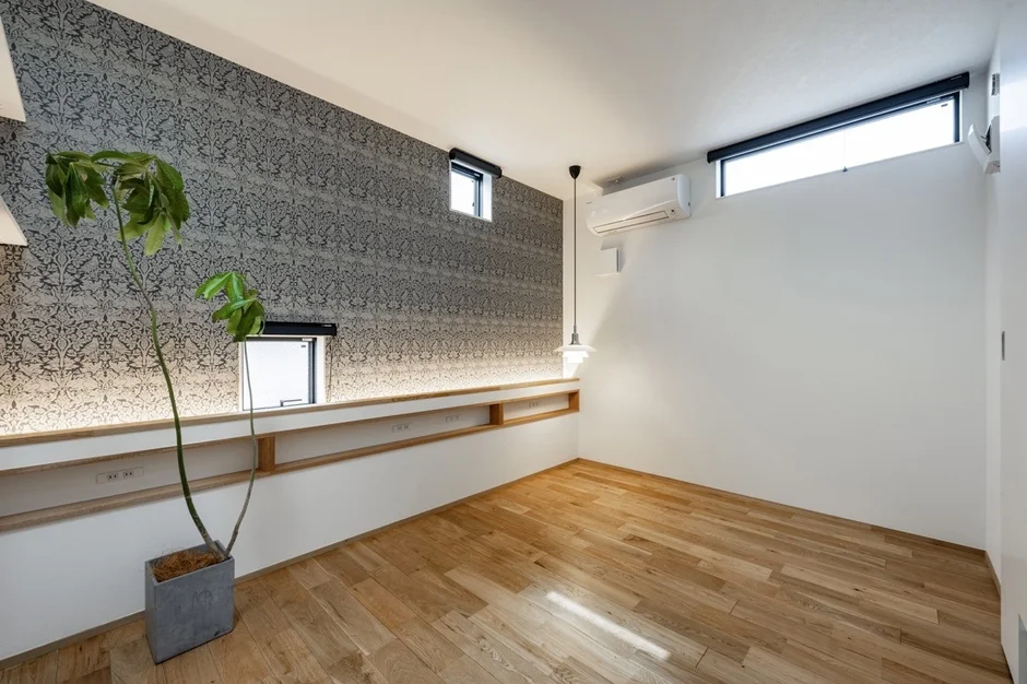 木目調のフローリングと特徴的な柄の壁紙が印象的なモダンな部屋の室内