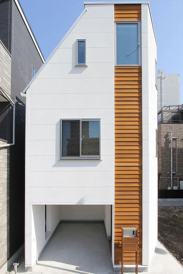青空の下に建つ、モダンでスタイリッシュな狭小住宅の外観