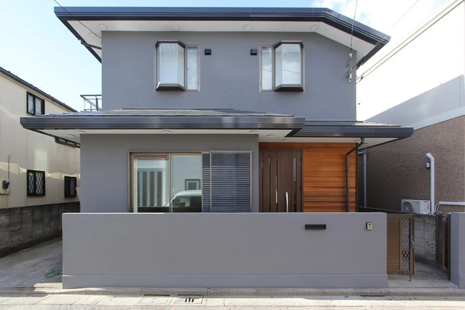 グレーの外壁が特徴的な、現代的なデザインの二階建て住宅