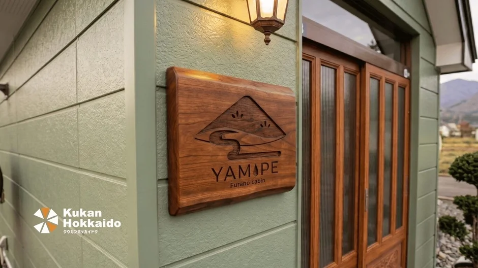 YAMAPE Furano cabinの木製看板が掲げられた建物の玄関部分