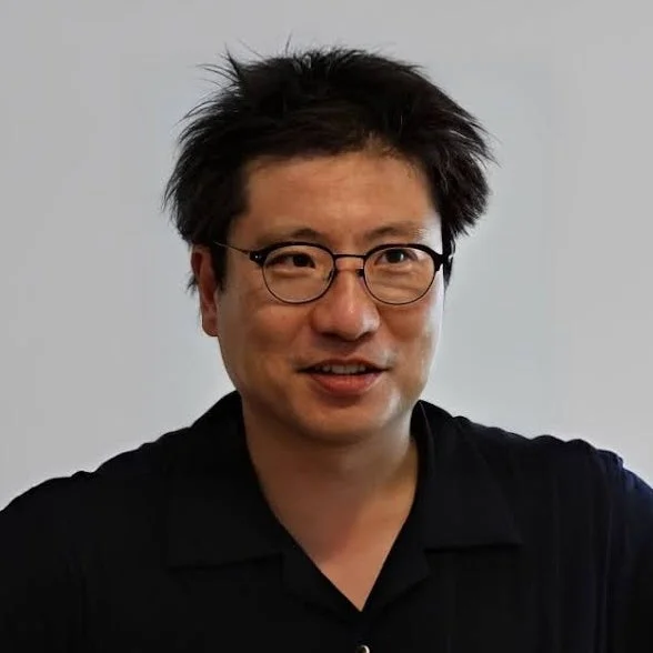 人物、男性、アジア人、眼鏡、黒シャツ、ポートレート、笑顔、ミドルエイジ、屋内、白背景