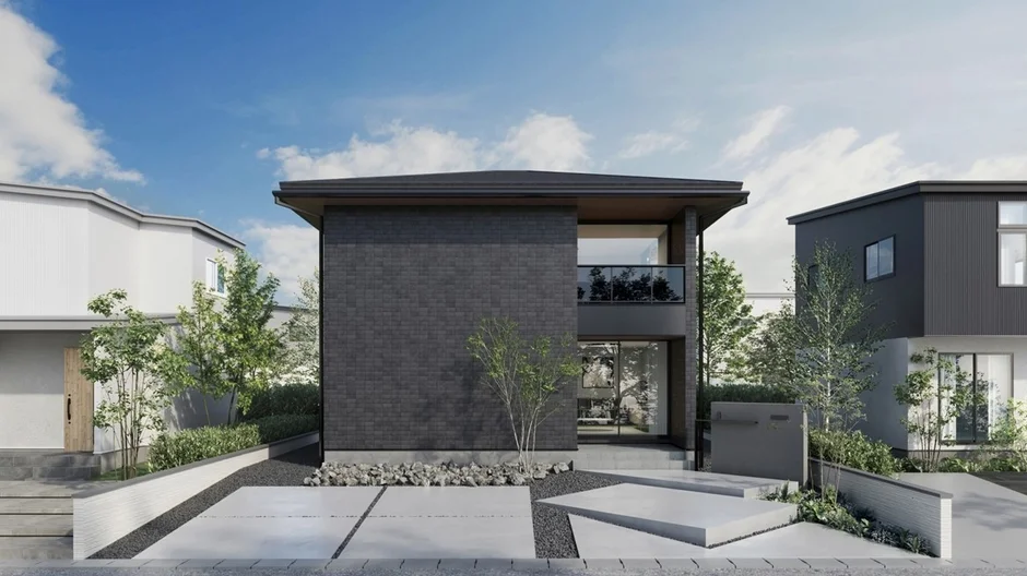 青空の下に建つモダンな黒い外壁の戸建て住宅
