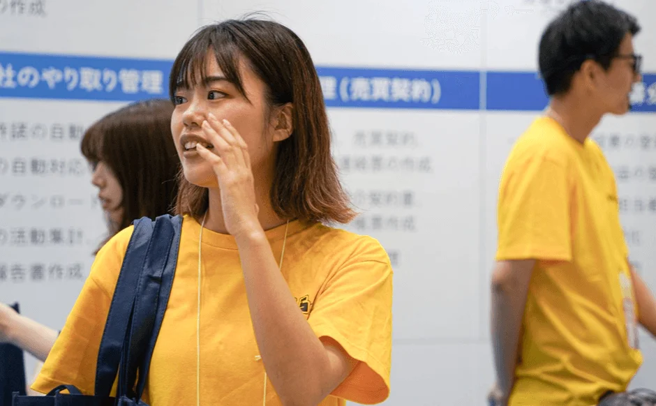 展示ブースでサービスを説明するスタッフ
