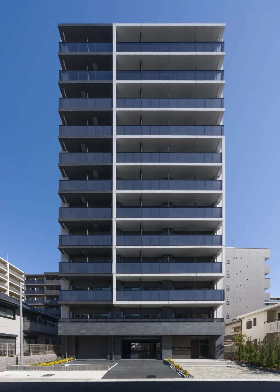 晴れ渡る青空の下に建つ、モダンなデザインの多層階マンション