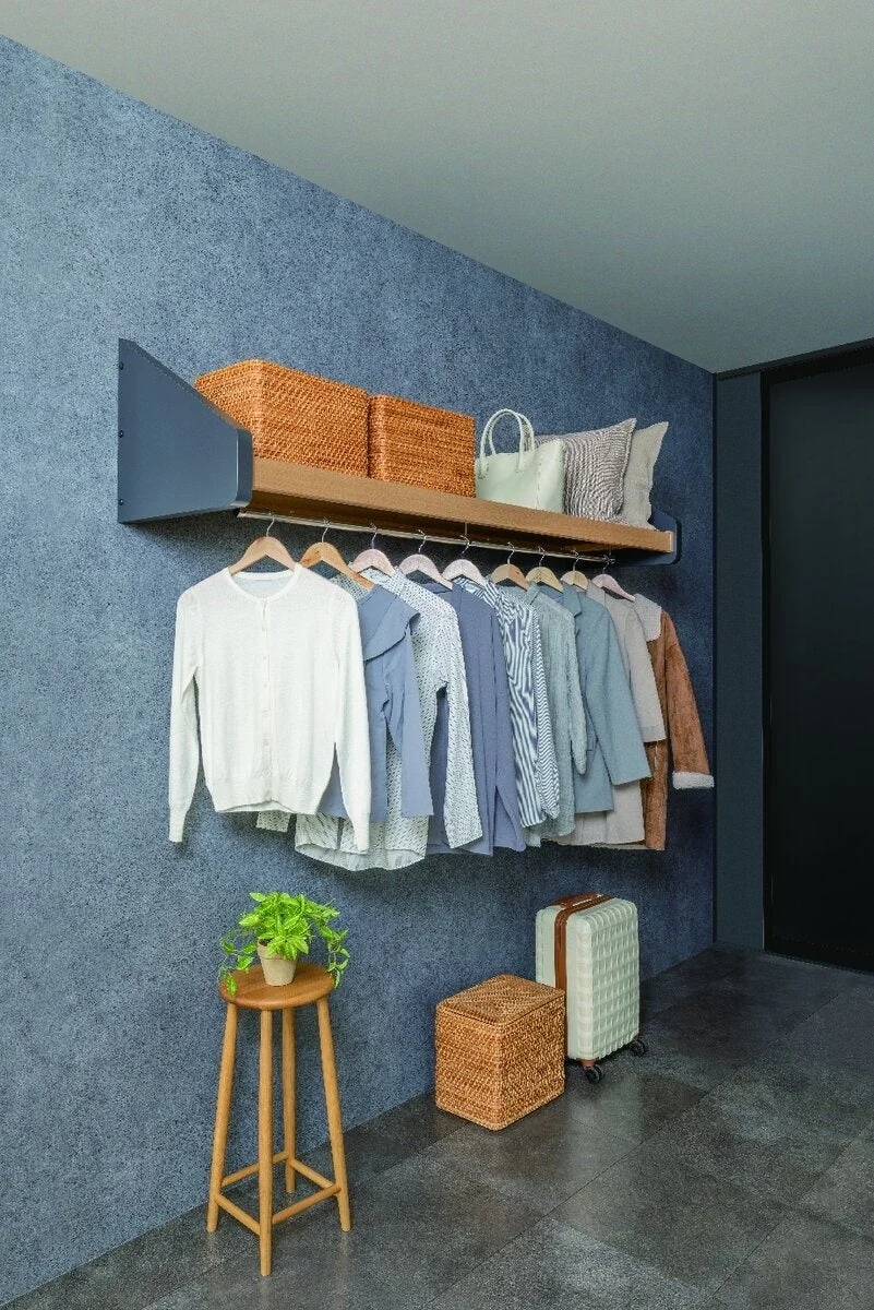 青灰色の壁の部屋に設置されたオープンクローゼット