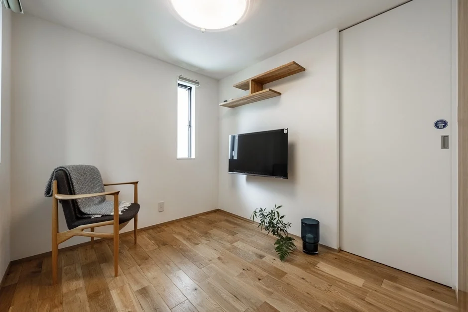 白い壁と木目調のフローリングが特徴の、明るく清潔感のあるモダンな部屋
