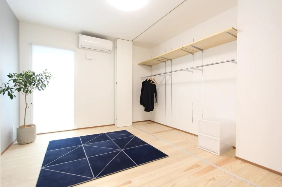 白い壁と明るいフローリングのモダンな部屋