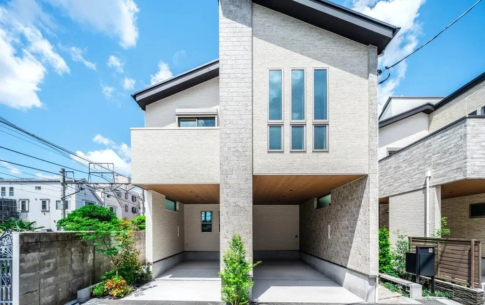 青い空の下、モダンなデザインの2階建て住宅