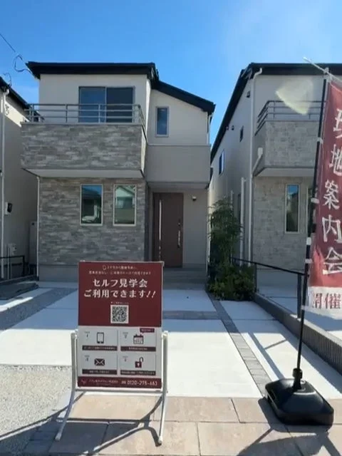セルフ見学会の看板と住宅外観