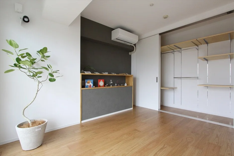白とグレーの壁に木の床が特徴の、明るくモダンな部屋
