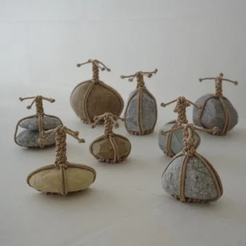 様々な形や色の石が紐で巻かれたアート作品