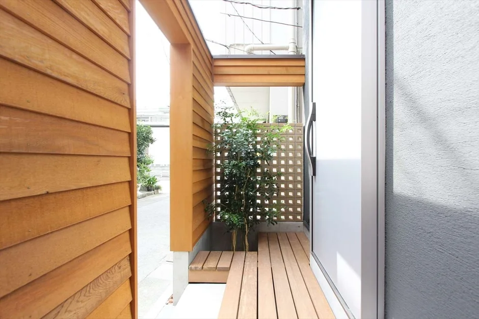 木製のルーバー壁とデッキがある屋外通路