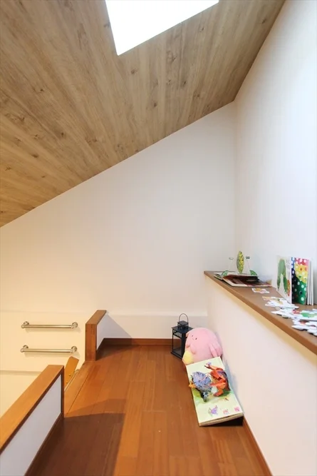 屋根裏部屋,ロフト,傾斜天井,天窓,木製フローリング,子供部屋,遊び場,本,ぬいぐるみ,インテリア,棚,手すり